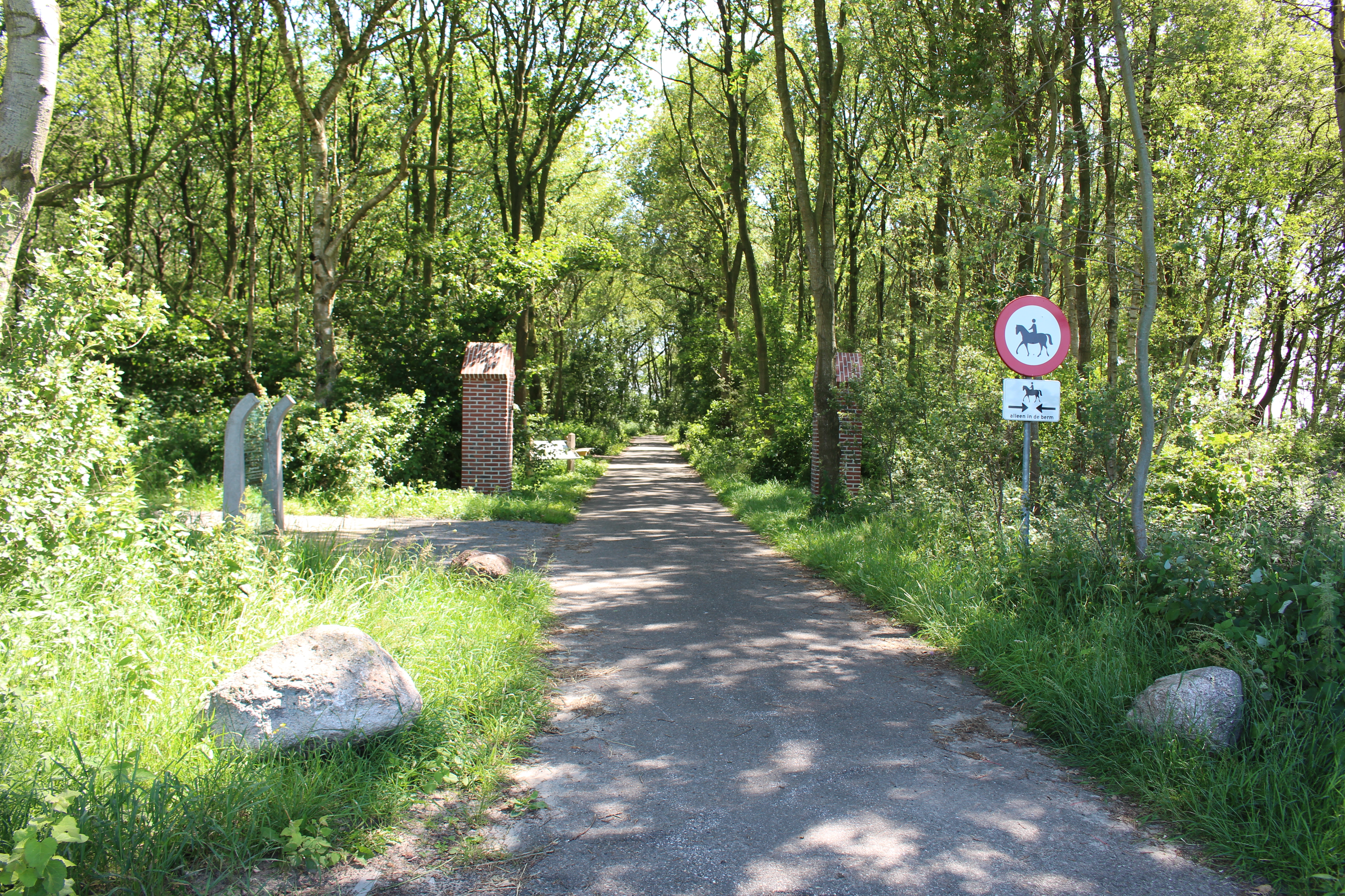 Ingang kamp Ybenheer met links het monument. De twee bakstenen zuilen zijn de overblijfselen van de originele toegang tot het kamp. Foto: marjolijn kok.