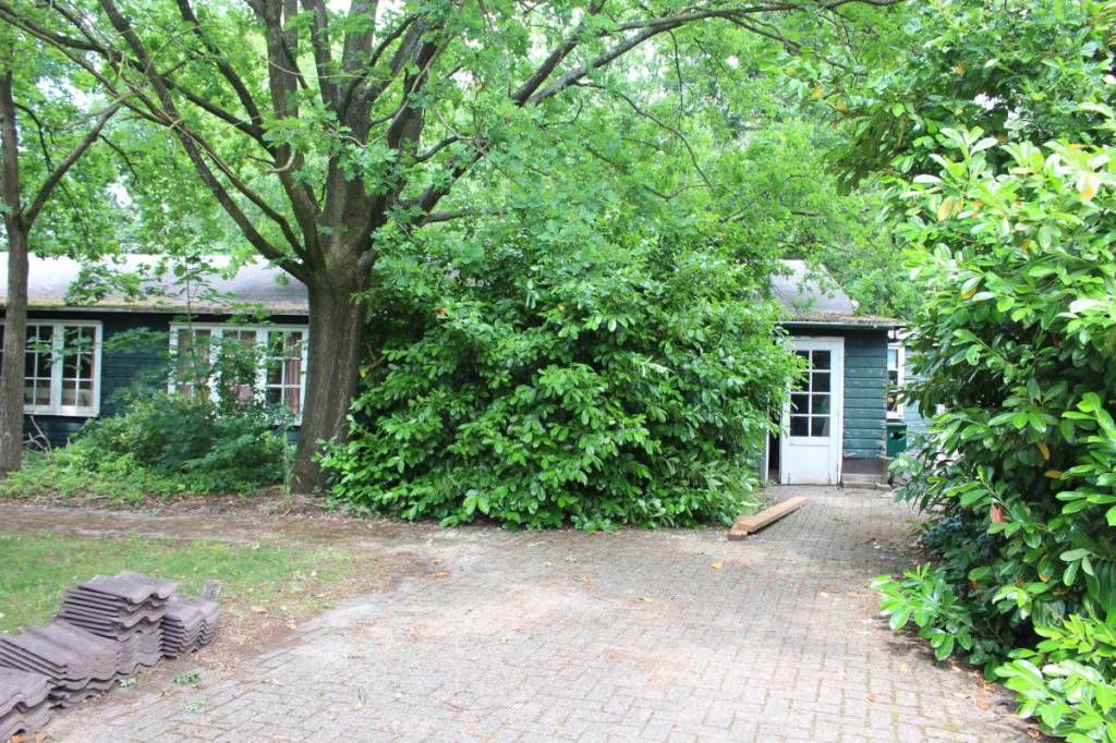 Oude barak uit het woonoord Baarschot van groen hout met witte kozijnen nu nog aanwezig.