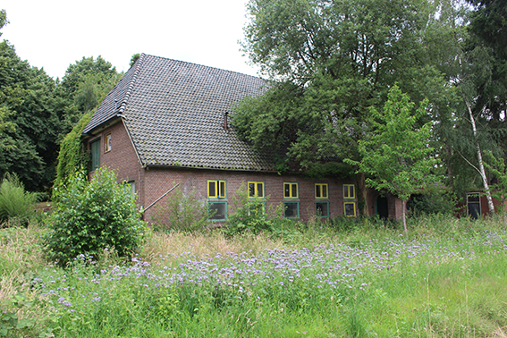Het gebouw dat op een boerderij lijkt met de kantine en het ketelhuis in kamp Voorts te Teuge.
